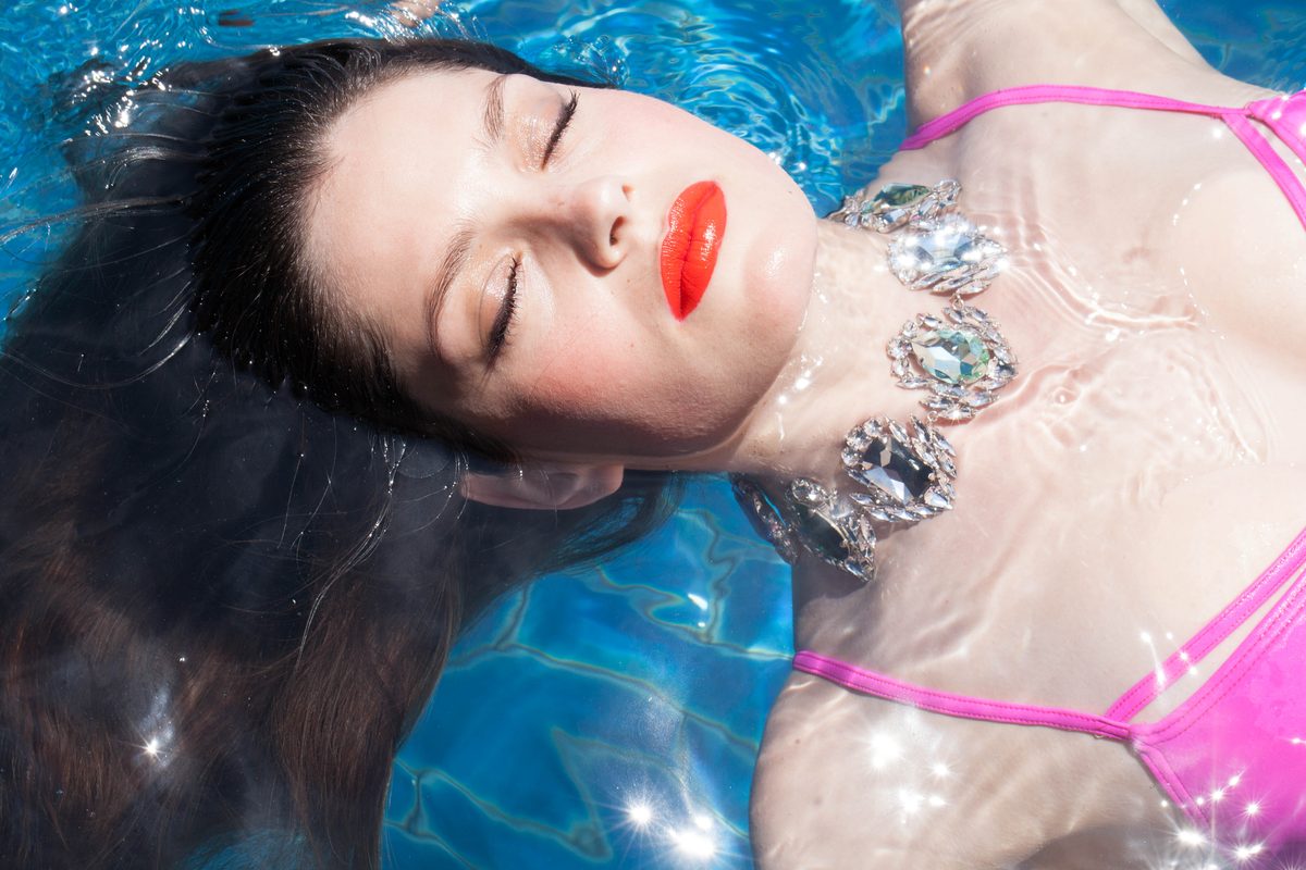 KORMELITZ Spring/Summer 2014: Swarovski crystal collar necklace in clear and blue-grey stones, worn floating in a swimming pool